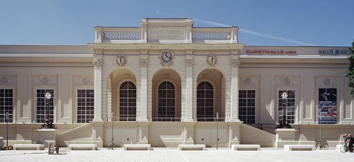 Exterior view of the Hall E+G building with blue sky and trees on the left and right.