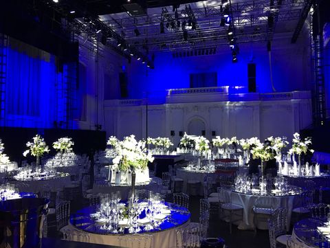 Atmospheric gala setting in Hall E of the MQ with festively decorated tables and white floral arrangements in a blue lighting atmosphere.
